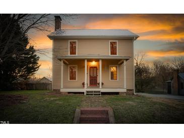 Charming two-story home featuring a welcoming front porch and beautiful sunset sky at 2416 Glencoe St, Burlington, NC 27217