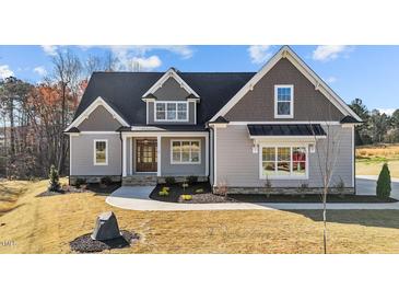 Charming home featuring a gray exterior, complemented by well-maintained landscaping at 25 Firefly Ln, Youngsville, NC 27596