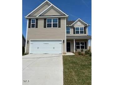 Charming two-story home with a two car garage, manicured lawn, and neutral colored siding at 238 Plains Dr # 313, Burlington, NC 27217