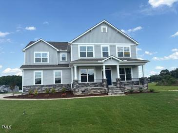 Two-story home boasting large windows, gray siding, and a well-manicured lawn under a blue sky at 111 Demascus Way # 021, Four Oaks, NC 27524