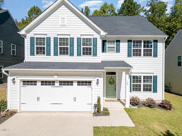 Charming two-story home featuring a two-car garage, green shutters and door, and a well-manicured lawn at 165 Tawny Slope Ct, Raleigh, NC 27603