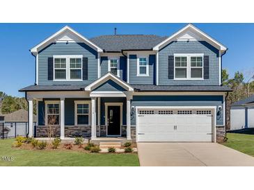 Charming two-story home with a two-car garage, blue siding, and stone accents at 114 Hickory Grove Dr, Sanford, NC 27330