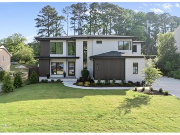 Stunning two-story home with modern design, manicured lawn, and elegant landscaping at 662 Manchester Dr, Raleigh, NC 27609
