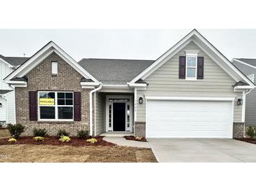 Charming single-Gathering home with a two-car garage, brick accents, and a well-manicured lawn at 1229 Cricket St, Elon, NC 27244