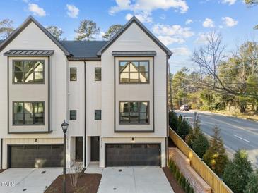 Modern townhome showcasing black-trimmed windows, dark garage doors, and a well-kept front yard at 811 Maple Berry Ln # 101, Raleigh, NC 27607
