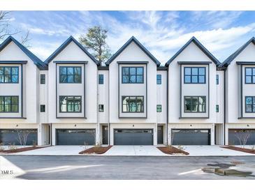 Beautiful exterior view of modern townhomes with sleek designs and a gray and white color palette at 811 Maple Berry Ln # 104, Raleigh, NC 27607