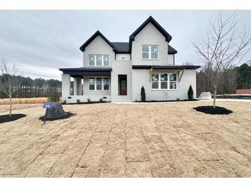 Two-story house with gray siding, black accents, and a landscaped yard at 55 Firefly Ln, Louisburg, NC 27549