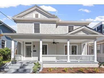 Inviting gray two-story home with a charming front porch and classic white columns at 215 E Cabarrus St, Raleigh, NC 27601