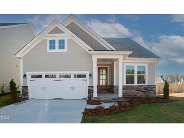 Charming single-Gathering home featuring a two-car garage, inviting entryway, and well-maintained landscaping at 239 Harvester Rd, Angier, NC 27501