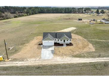 Expansive aerial view of a charming white home surrounded by a sprawling green landscape at 233 Surles Rd, Benson, NC 27504
