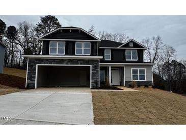 Two-story home with stone accents, an attached two-car garage, and a well-manicured lawn at 73 High Hampton Way, Fuquay Varina, NC 27526