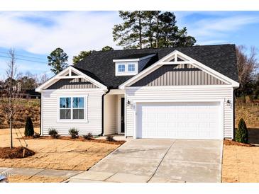 Charming single-story home featuring a two-car garage and professionally landscaped front yard at 326 Little Creek Dr, Lillington, NC 27546
