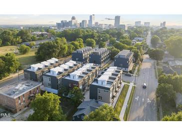 Stunning aerial view of modern townhomes with a cityscape backdrop, surrounded by lush greenery at 10 Seawell Ave # 105, Raleigh, NC 27601