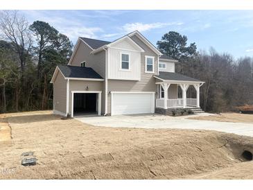 Charming two-story home with a covered porch, two-car garage, and a well-maintained lawn at 240 Fast Pitch Ln, Four Oaks, NC 27524