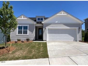 Charming one-story home with a well-manicured lawn, attached two-car garage and classic curb appeal at 96 Little Creek Dr, Lillington, NC 27546