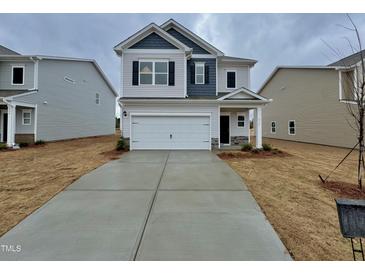 Charming two-story home with a two-car garage and a well-manicured front yard at 216 Bruce Dr, Dunn, NC 28334