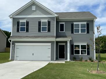 Charming two-story home featuring gray siding, black shutters, and a two-car garage on a well-maintained lawn at 158 Citizens Ct # 32, Four Oaks, NC 27524