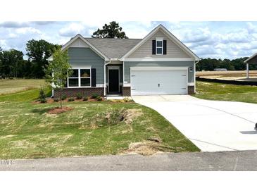 New construction craftsman-style home with brick detail, a well-manicured lawn, and attached garage at 346 Olivia Crossing Ct # 12, Four Oaks, NC 27524