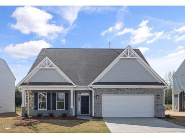 Charming single-story home featuring a stone facade, two-car garage, and well-maintained landscaping at 1232 Cricket St, Elon, NC 27244