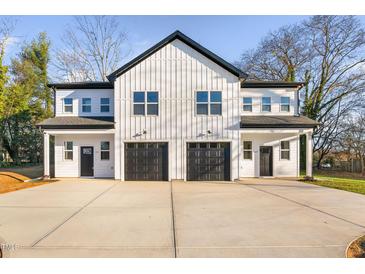 Modern duplex with white siding, black garage doors, and ample parking at 329 & 331 Roxboro St, Haw River, NC 27258
