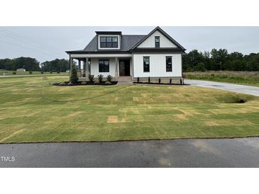 New construction home with a manicured lawn and landscaping and a covered porch at 5124 Grist Stone Way, Youngsville, NC 27596