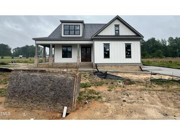 New construction white farmhouse with a brick foundation, and a covered front porch at 5124 Grist Stone Way, Youngsville, NC 27596