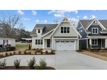 Beautiful two-story home featuring a classic white garage and a well-maintained front yard at 418 S Cross St, Youngsville, NC 27596