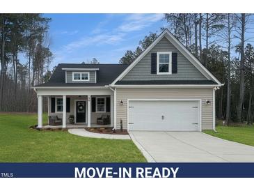 Charming home featuring a manicured lawn, two-car garage and a welcoming front porch at 50 N Rowsham Pl, Smithfield, NC 27577