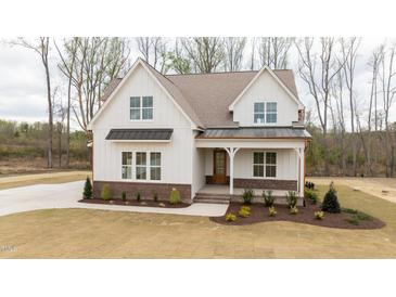 Charming two-story home with a welcoming front porch and meticulously landscaped front yard at 8624 Dukes Lake Rd, Zebulon, NC 27597