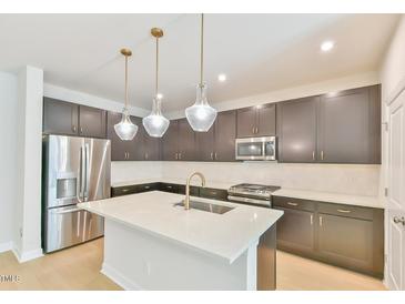 Modern kitchen features stainless steel appliances, a kitchen island, and stylish pendant lighting at 140 Norwell Ln, Pittsboro, NC 27312