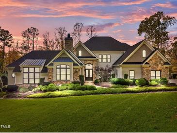 Stunning home with stone accents, lush landscaping, and a charming entrance under a beautiful sky at 110 Bywater Way, Chapel Hill, NC 27516