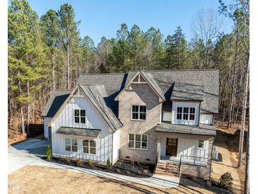 Two-story brick and siding home with black mulch landscaping, a gray roof, and a large front yard at 1226 Red Cedar Ct, Youngsville, NC 27596