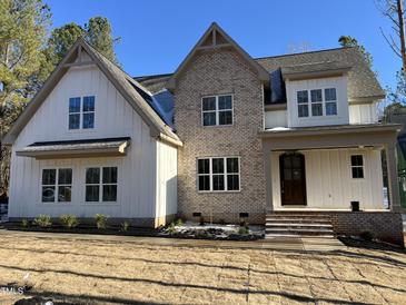 Two-story home with brick and white siding, showcasing a charming farmhouse style at 1226 Red Cedar Ct, Youngsville, NC 27596