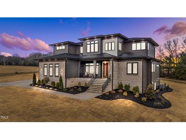 Stunning two-story home with stone and siding accents, professional landscaping, and a welcoming covered front porch at 30 Hartwood Ln, Youngsville, NC 27596
