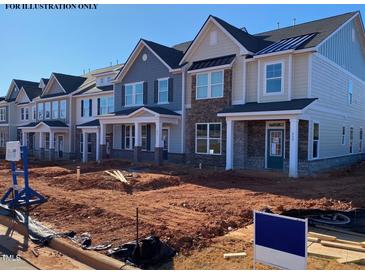 New construction townhomes featuring varying exterior finishes and landscaping in progress under a clear blue sky at 937 Alma Railway Dr # 555, Wake Forest, NC 27587