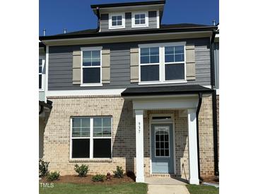 Charming two-story home with brick facade, gray siding, and a welcoming light-blue front door at 937 Alma Railway Dr # 555, Wake Forest, NC 27587