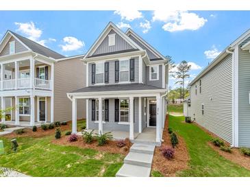 Charming two-story home featuring gray siding, black shutters, and a welcoming front porch with white columns at 276 White Oak Garden Way # 210, Garner, NC 27529