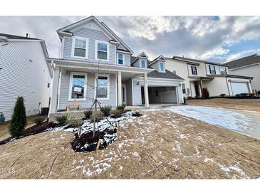 Two-story house with gray siding, attached garage, and landscaping at 327 Creekhaven Dr # 157, Angier, NC 27501