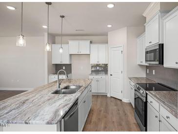 Modern kitchen with granite countertops and stainless steel appliances at 65 Wild Turkey Way Way, Lillington, NC 27546