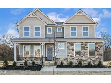 Two-story house with stone and shingle accents, front porch, and landscaping at 87 Browning Mill Dr, Wendell, NC 27591