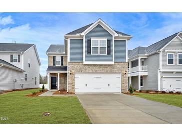 Charming two-story home featuring a brick and siding facade, a two-car garage, and a well-manicured lawn at 87 Nimble Way # 187, Clayton, NC 27520