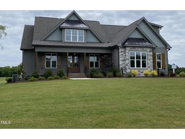 Beautiful single-Gathering home featuring a well-manicured lawn and a combination of stone and siding accents at 20 Water Willow Ln, Zebulon, NC 27597