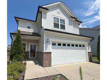 Charming two-story home featuring a two-car garage, light gray siding, and well-maintained landscaping at 2117 Attend Xing, Fuquay Varina, NC 27526