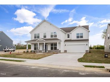 Beautiful white two-story home with a covered front porch and a two-car garage at 1233 Cricket St, Elon, NC 27244