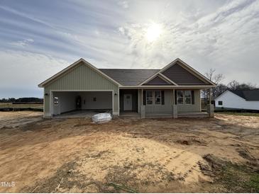 Charming single-story home with green siding, garage and inviting front porch in a developing neighborhood at 141 Ruskin Dr, Smithfield, NC 27577