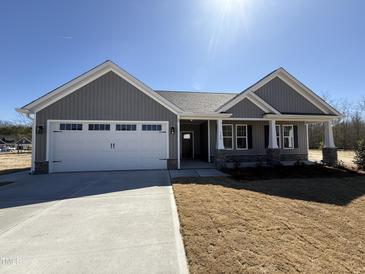 Charming one-story home with gray siding, stone accents, and a two-car garage at 700 Tuscany Cir, Princeton, NC 27569