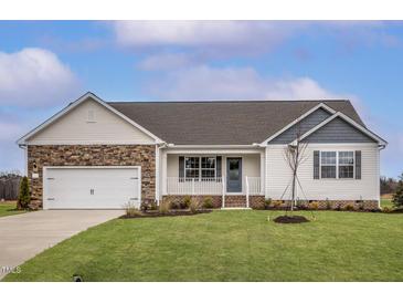 Charming single-story home featuring a stone-accented garage and covered front porch at 11320 International Dr, Middlesex, NC 27557