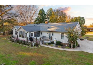 Charming home with a screened porch, lush landscaping, and a well-manicured lawn at 185 Franklin Ln, Henderson, NC 27537