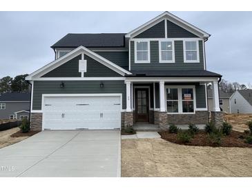 Charming two-story home features an attached two-car garage and stone accents at 409 Marthas View Way, Wake Forest, NC 27587