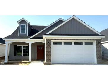 Charming new home with a two-car garage, brick accents, and a welcoming covered front porch at 180 Brunswick Dr, Nashville, NC 27856